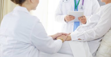 Doktor, kadın hastasına teşhisi açıklıyor.