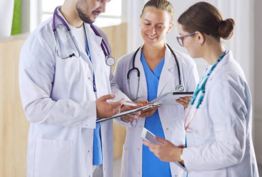 Doktor tabletinde tıbbi ekibine bir şey gösteriyor.