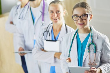 Bir grup doktor ve hemşire hastane odasında bekliyor.