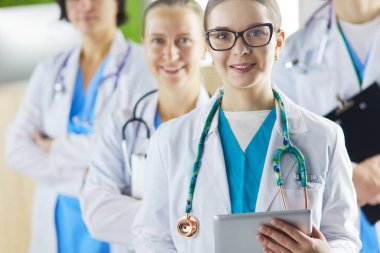 Bir grup doktor ve hemşire hastane odasında bekliyor.