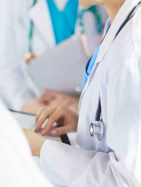 Dokter laat iets in zijn tablet zien aan zijn medische team. — Stockfoto