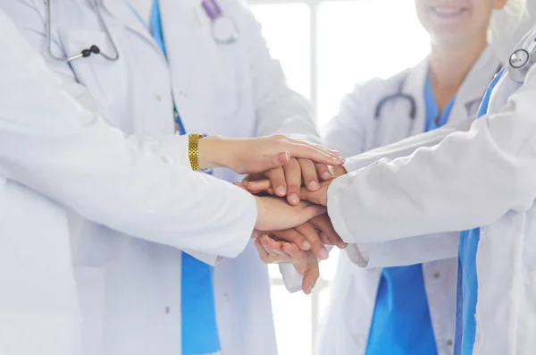 Γιατροί και νοσοκόμες στοιβάζουν τα χέρια τους. Απομονωμένα σε λευκό — Φωτογραφία Αρχείου