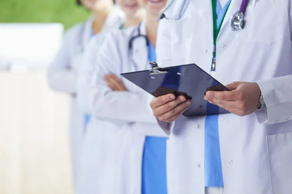 Happy medical team comprising male and female doctors smiling broadly and giving a thumbs up of success and hope — 스톡 사진