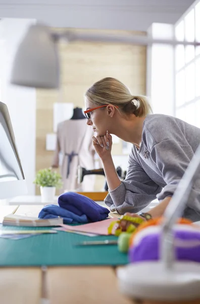 Jonge aantrekkelijke vrouwen mode ontwerpers leunend op kantoor, werken met een laptop — Stockfoto