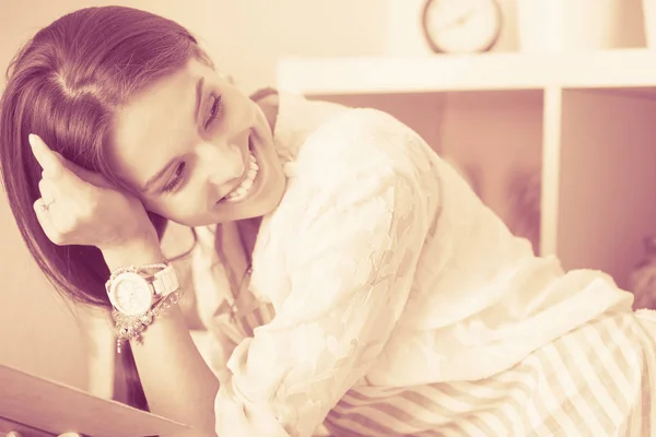 Young woman sitting a table in the kitchen. Young woman — Stock Photo, Image