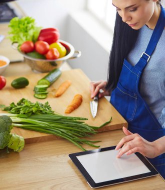 Mutfakta sebze doğrayan genç bir kadın.