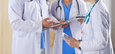 Doktor tabletinde tıbbi ekibine bir şey gösteriyor.