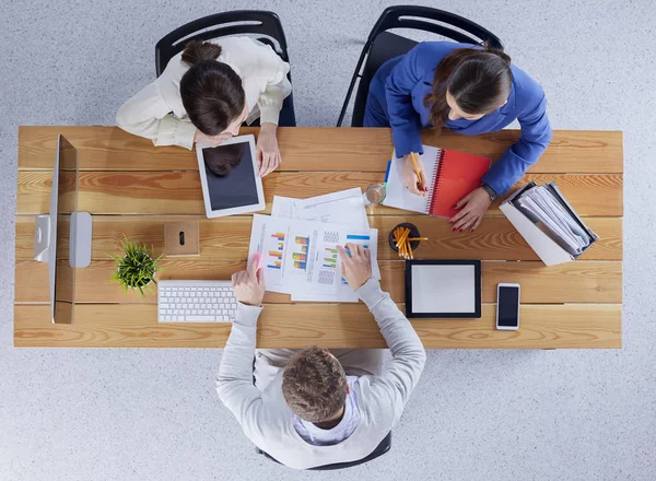 Jovens empresários sentados na mesa trabalhando juntos usando o computador portátil — Fotografia de Stock