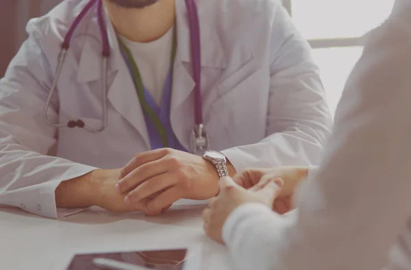 Retrato de um médico do sexo masculino com laptop sentado na mesa no consultório médico — Fotografia de Stock