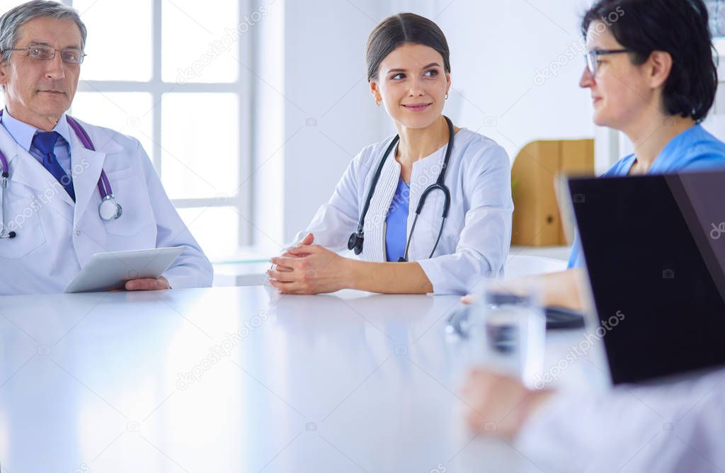 Serious medical team discussing patients case in a bright office