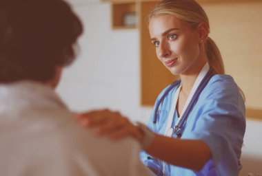 Doktor ve hasta tarama sonuçlarını tarama merkezinde tartışıyor