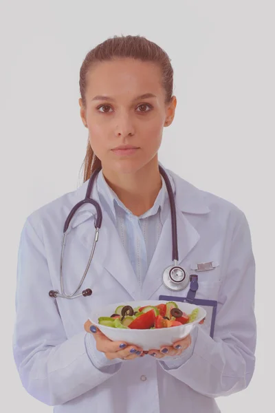 Портрет красивої жінки-лікаря, що тримає тарілку зі свіжими овочами. Жінка лікарі . — стокове фото