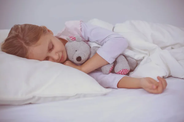 Niño niña duerme en la cama con un osito de peluche de juguete . —  Fotos de Stock