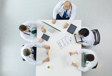 Tıbbi ekip masaya oturuyor ve tartışıyor.