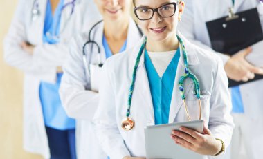 Bir grup doktor ve hemşire hastane odasında bekliyor.