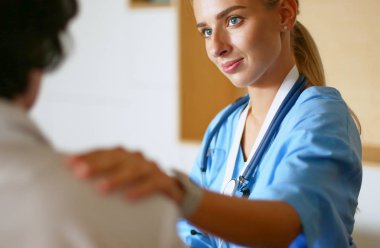 Doktor ve hasta tarama sonuçlarını tarama merkezinde tartışıyor