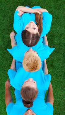 Yeşil çimenlerin üzerinde oturan genç insanlar grubudur. Selfie