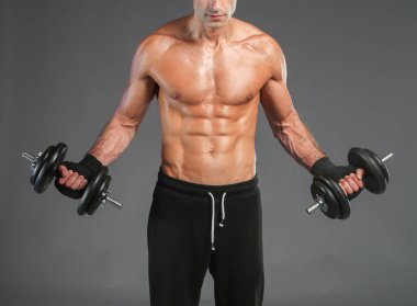 Yakışıklı kaslı adam dumbell ile çalışma dışarı. Kişisel fitness eğitmeni. Kişisel eğitim.