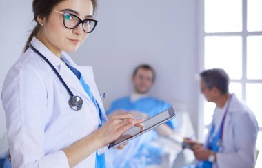 Hastane lobisinde tablet bilgisayar kullanan kadın doktor.