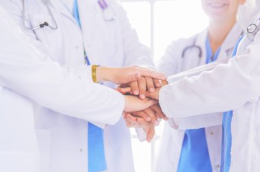 Doktorlar ve hemşireler el ele tutuşuyor. Beyazda izole edilmiş