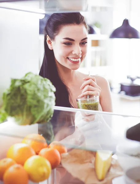 Young woman with glass of tasty healthy smoothie at table in kitchen — Stock Photo, Image