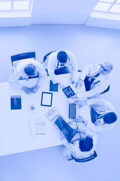 Medisch team zit en discussieert aan tafel, bovenaanzicht — Stockfoto