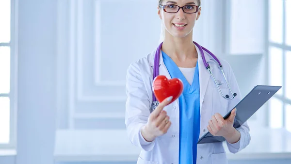 Médica com o estetoscópio segurando o coração — Fotografia de Stock