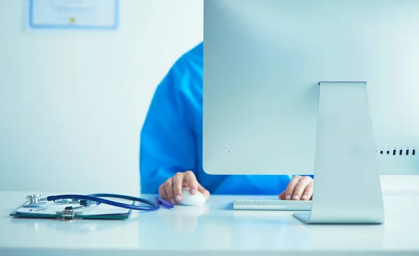 Kobieta lekarz siedzi i pracuje na laptopie — Zdjęcie stockowe
