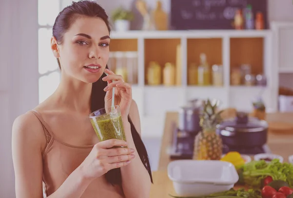 Giovane donna con vetro di frullato sano saporito a tavola in cucina — Foto Stock