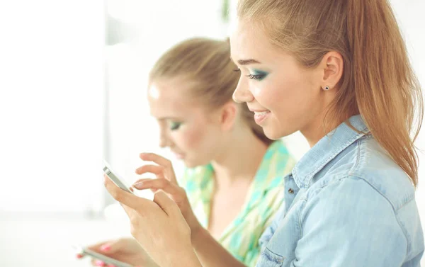 Vackra unga kvinnor som använder en moblie telefon — Stockfoto