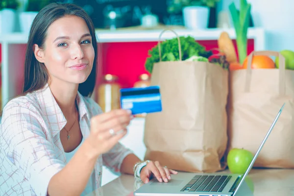 Femme souriante achats en ligne en utilisant tablette et carte de crédit dans la cuisine. Femme souriante — Photo