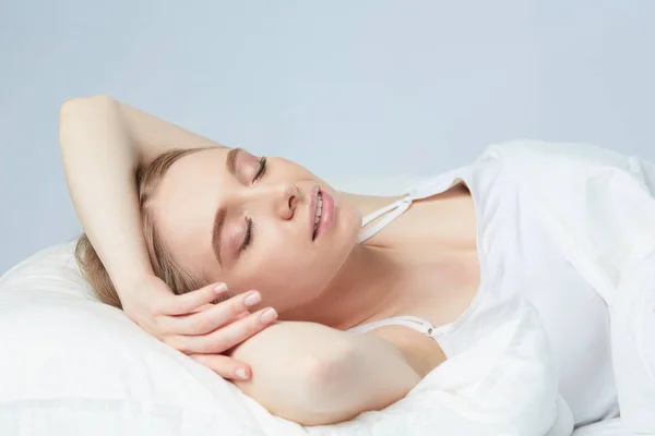 Photo of sleeping young woman lying in bed with eyes closed — Stock Photo, Image