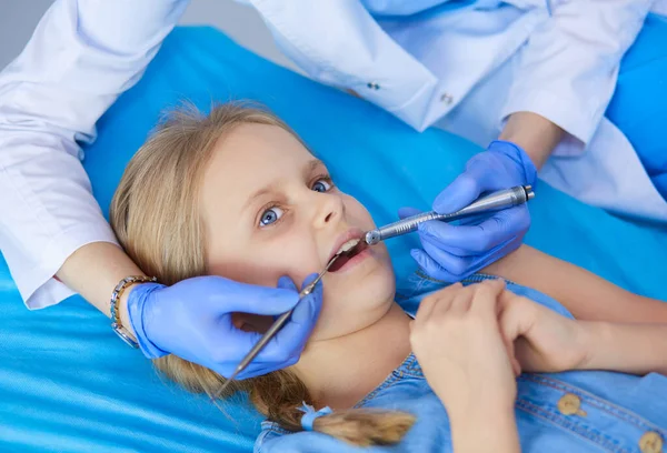 Niña sentada en el consultorio de dentistas. — Foto de Stock