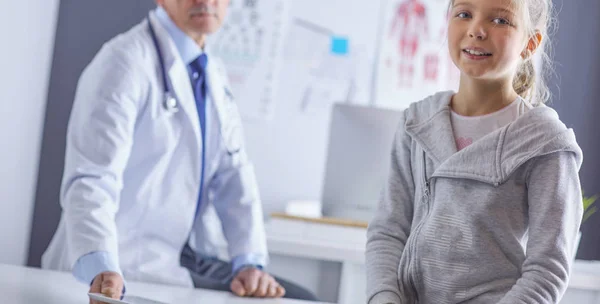 Portrait of a cute little girl and her doctor at hospital — Stock Photo, Image