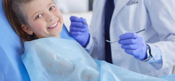 Niña sentada en el consultorio de dentistas — Foto de Stock