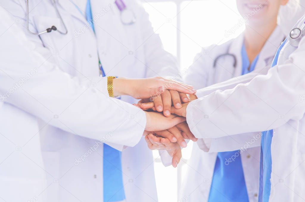 Doctors and nurses stacking hands. Isolated on white