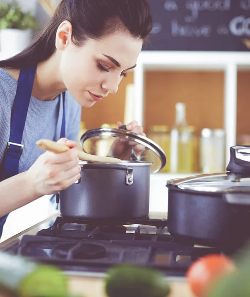 Mujer cocinera en cocina con cuchara de madera — Foto de Stock