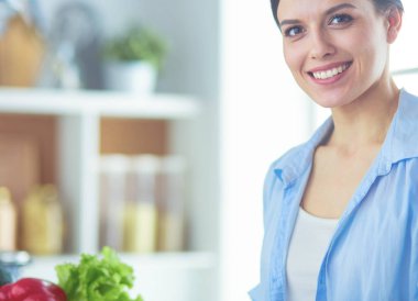 Mutfakta sebze doğrayan genç bir kadın..