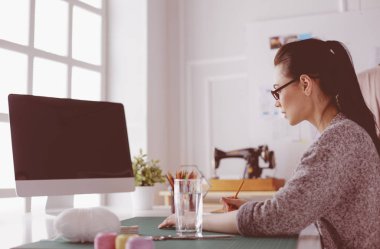 Moda tasarımcısının stüdyosunda çalışan portresi.