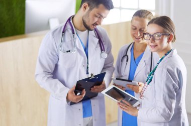 Doktor tabletinde tıbbi ekibine bir şey gösteriyor.