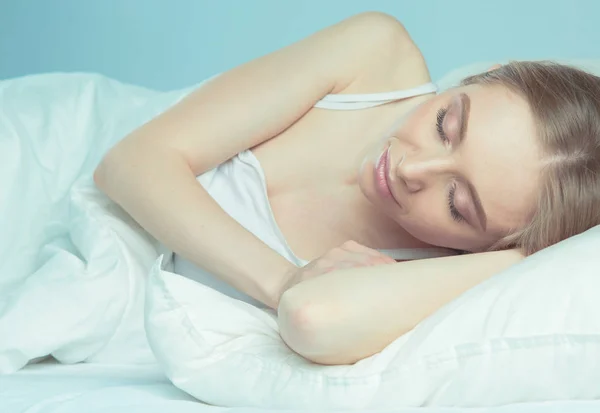 Foto de uma jovem adormecida deitada na cama com os olhos fechados — Fotografia de Stock