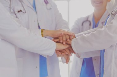 Doktorlar ve hemşireler el ele tutuşuyor. Beyazda izole edilmiş