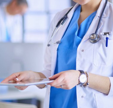 Hastane lobisinde tablet bilgisayar kullanan kadın doktor.