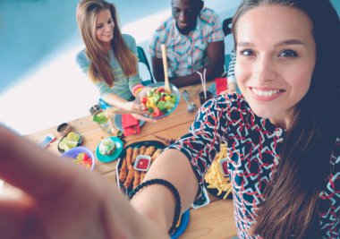 Öğle yemeği sırasında selfie çeken bir grup insan. Kendim. Arkadaşız. Arkadaşlar yemek yerken fotoğraflanır.