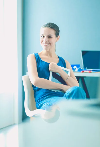 Jovem sentada na mesa com instrumentos, plano e laptop. — Fotografia de Stock