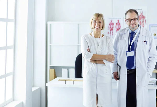 Medici che sorridono alla macchina fotografica nello studio medico — Foto Stock