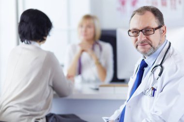 Hastanede bir iş yerinde gülümseyen tıp doktorları