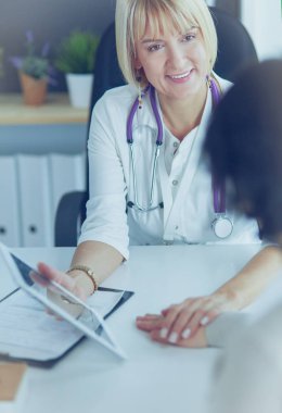 Doktor, kadın hastasına teşhisi açıklıyor.