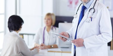 Boynunda steteskopla kameraya bakan bir doktor.