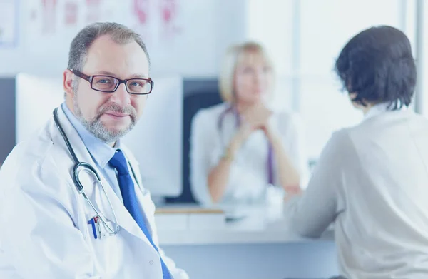 Lächelnde Ärzte an einem Arbeitsplatz im Krankenhaus — Stockfoto